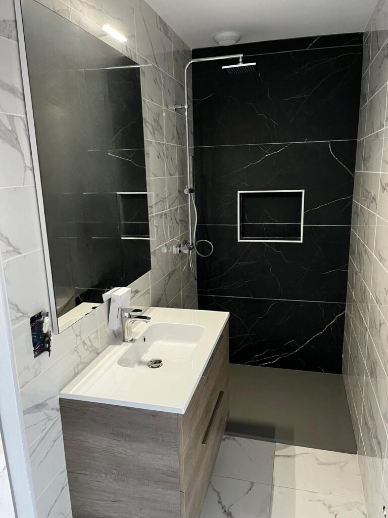 Salle Bain Moderne : Meuble-Lavabo, Carrelage Marbre Noir Salle de bain moderne avec meuble-lavabo bois flotté, miroir, douche à l'italienne carrelage marbre noir et blanc. Installation en cours.